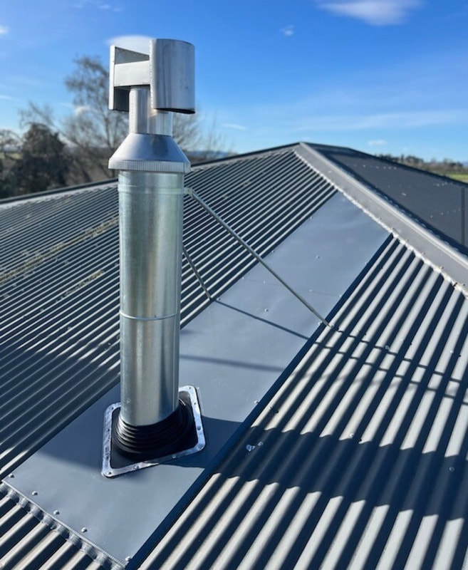 Flue and cowl freshly serviced on a corrugated roof
