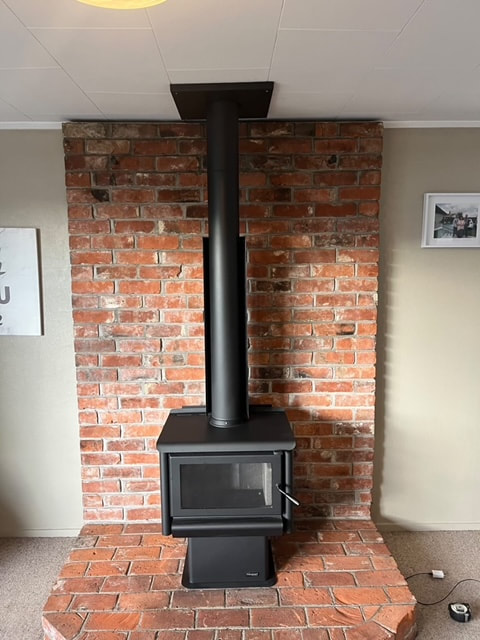 Wood burner against exposed brick chimney
