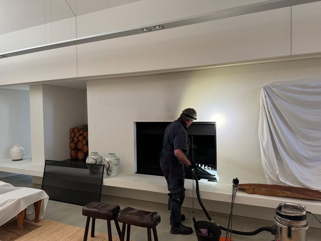 Chimney sweep servicing a modern architectural fireplace in a Central Otago home