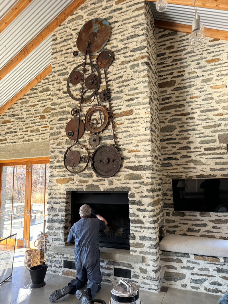 Mac sweeping a large schist stone chimney in a Central Otago home